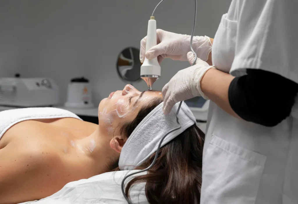 Woman receiving professional facial laser treatment at Two Chicks Aesthetics in Port Jefferson NY