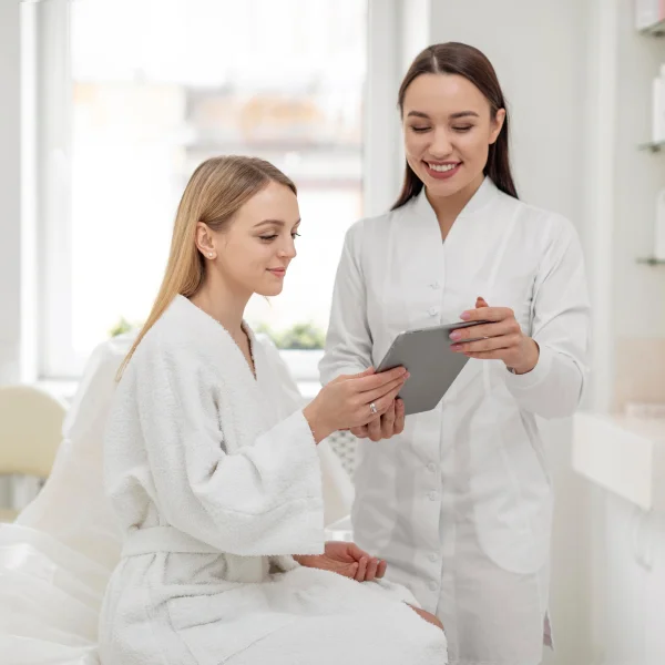 Aesthetic provider discussing treatment options with client during consultation at Two Chicks Aesthetics in Port Jefferson NY