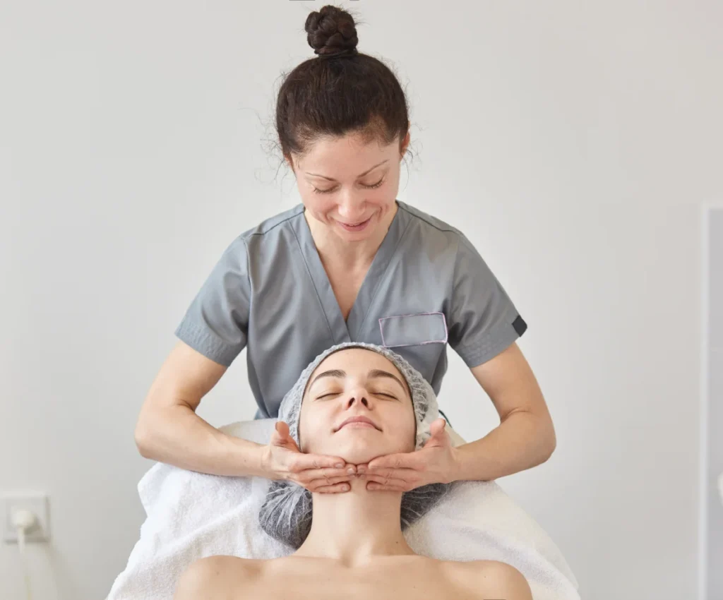 Aesthetic specialist performing facial massage treatment at Two Chicks Aesthetics in Port Jefferson NY