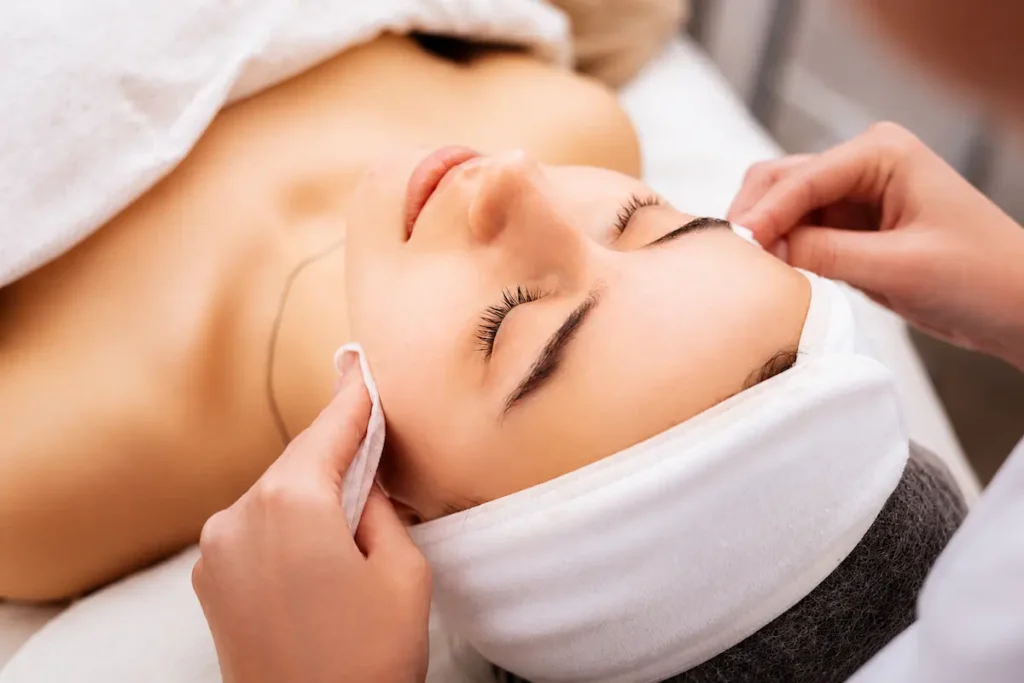 Woman receiving a relaxing medspa treatment facial with skincare cleansing and professional spa therapy in a luxury wellness clinic.
